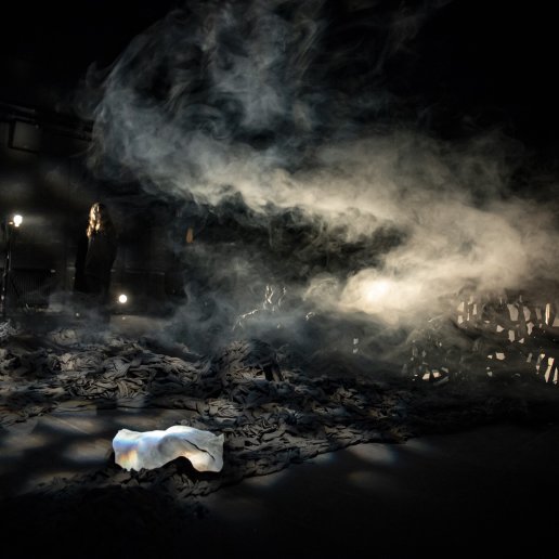 Na scenie scenografia spektaklu – wielkie płachty czarnego materiału, mnóstwo dymu spowijającego scenę.