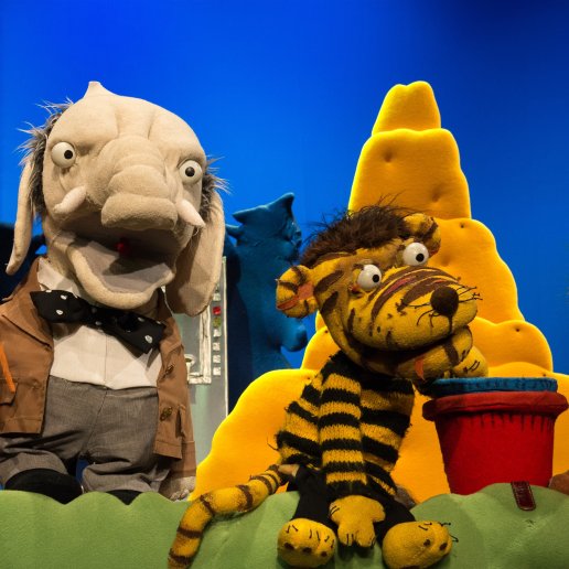 Lew, Słoń i Tygrysek stoją przy kopcu usypanym z piasku. Tygrysek trzyma plastikowe wiaderka.