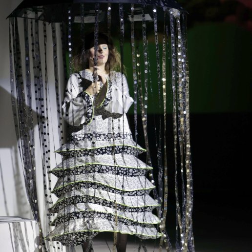 Aktorka w srebrnej sukni i parasolem z cekinami.