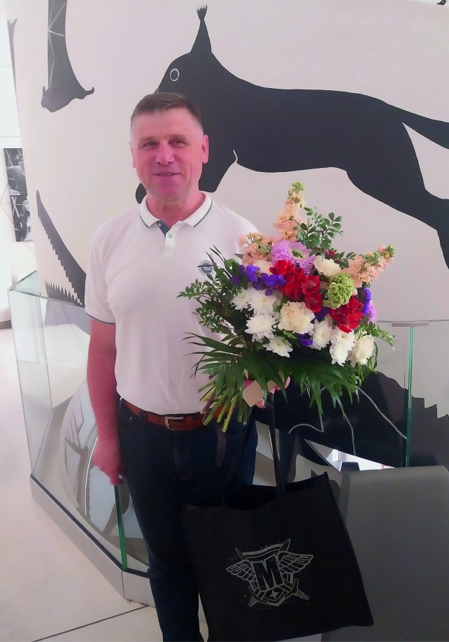 Bernard Pyrek z bukietem kwiatów i prezentem